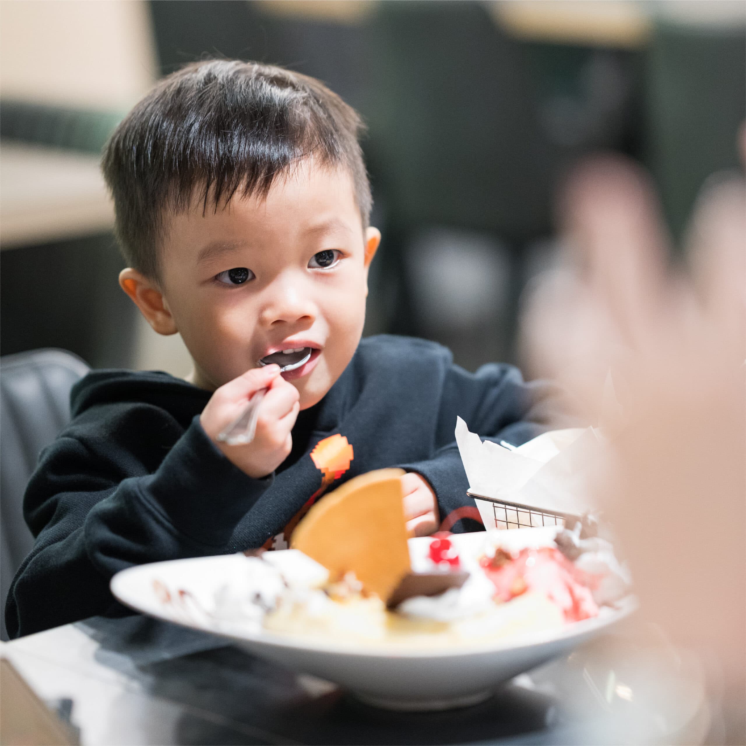 A child enjoying ice cream at a restaurant celebration.