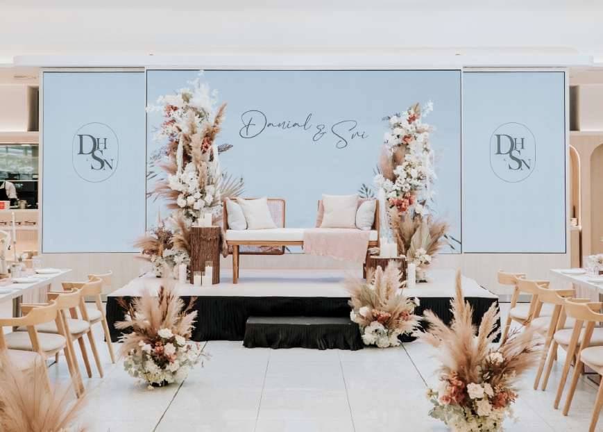 The Acacia Geneo set for a wedding, with a floral aisle and a pastel ceremony backdrop